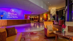 En lobby med reception, siddeområde og et stort vindue.