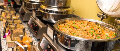 A buffet setup with various food items and a digital control panel.