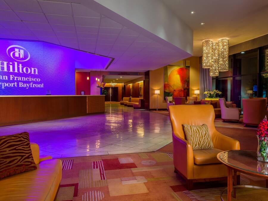 A lobby with a reception desk, seating area, and a large window.