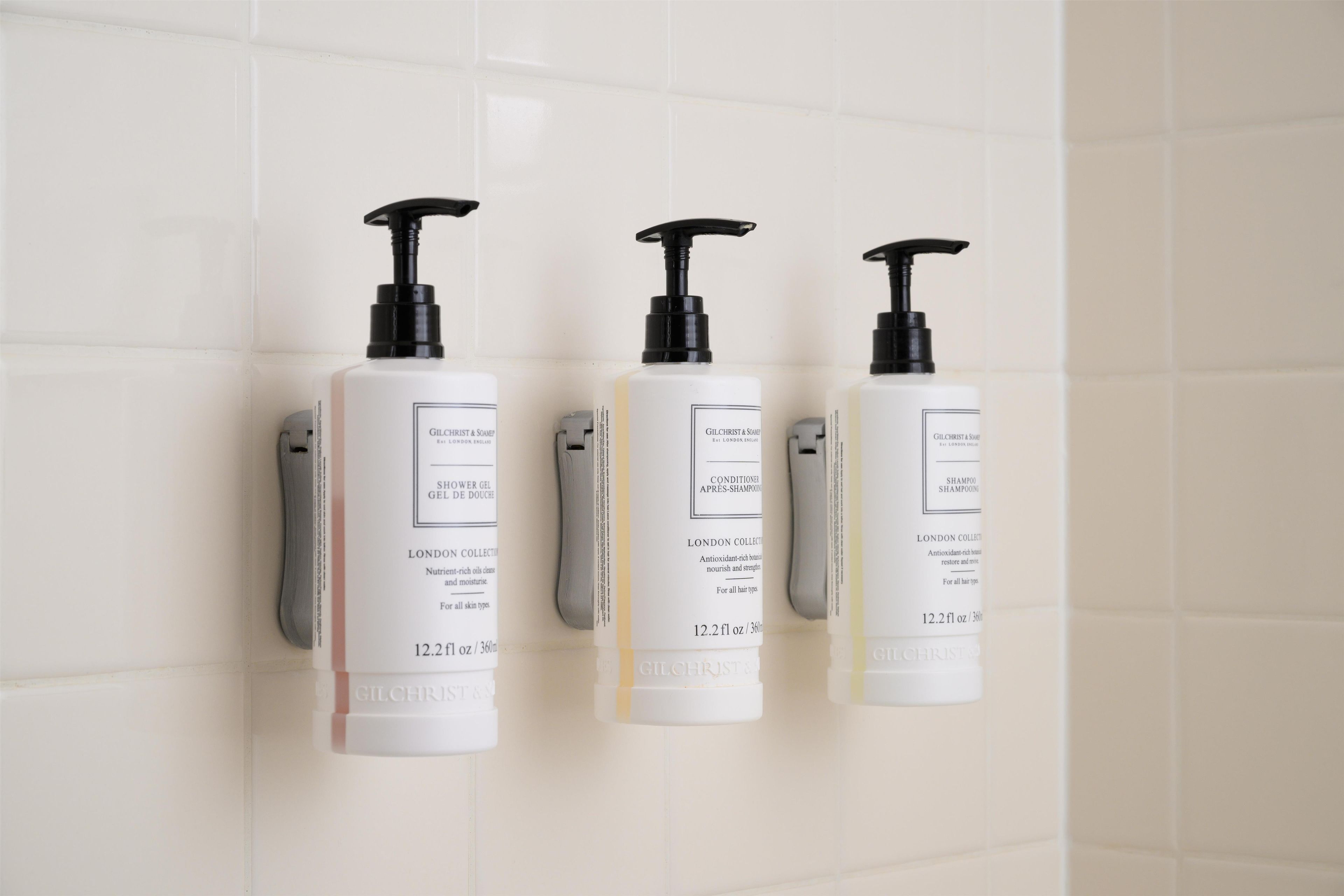 Three Gilchrist & Soame London Collection bottles on a white tiled wall.
