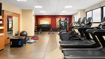 A gym with treadmills, weight machines, and free weights.