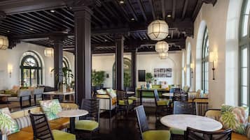 A spacious lobby with high ceilings, large windows, and a variety of seating arrangements including sofas and chairs.