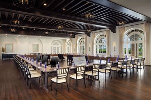 A conference room with long tables, chairs, and a 'Casa Mannia' sign.