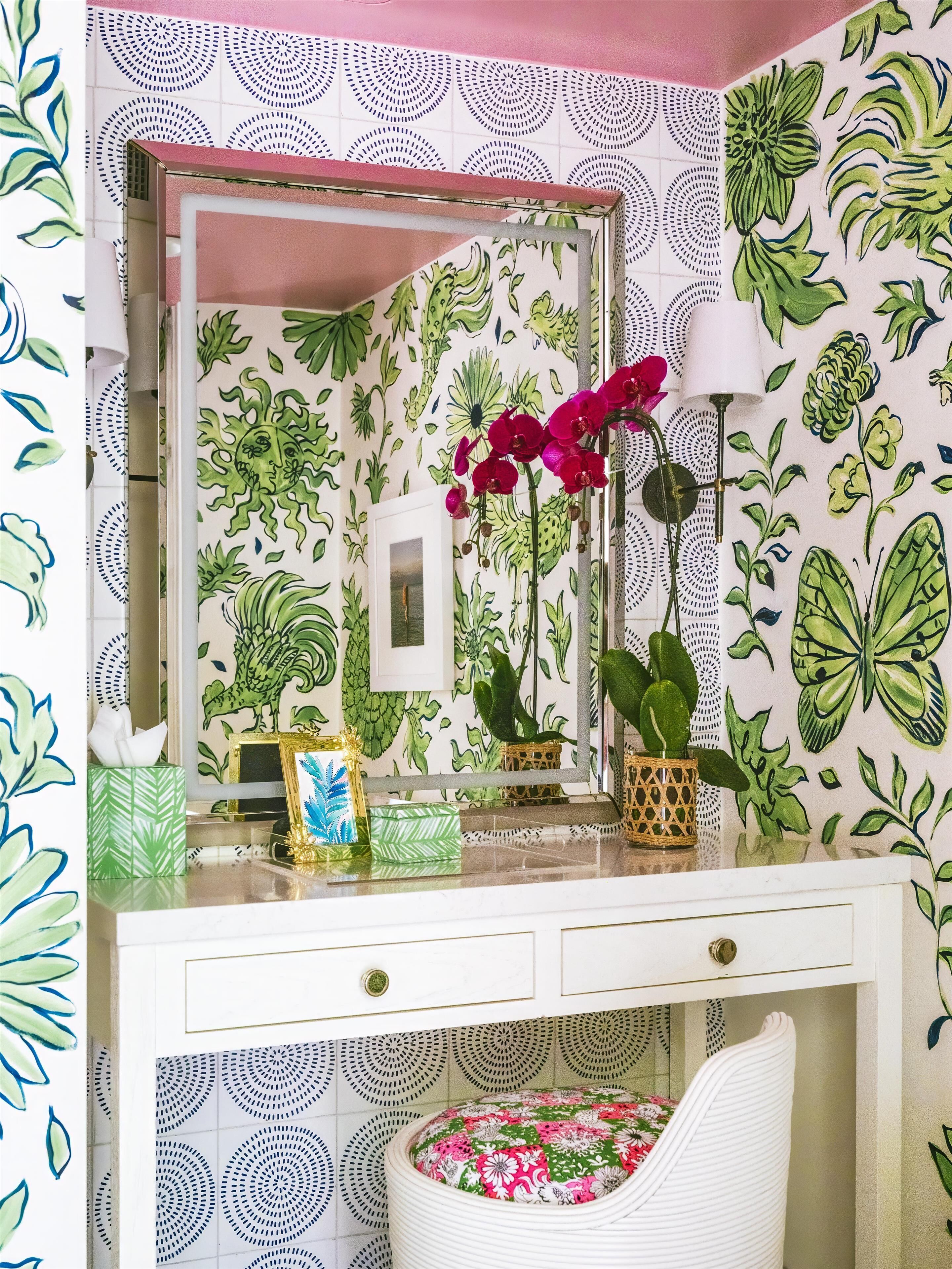A vanity with a mirror, a small plant, a tissue box, and a framed picture on a white dresser.