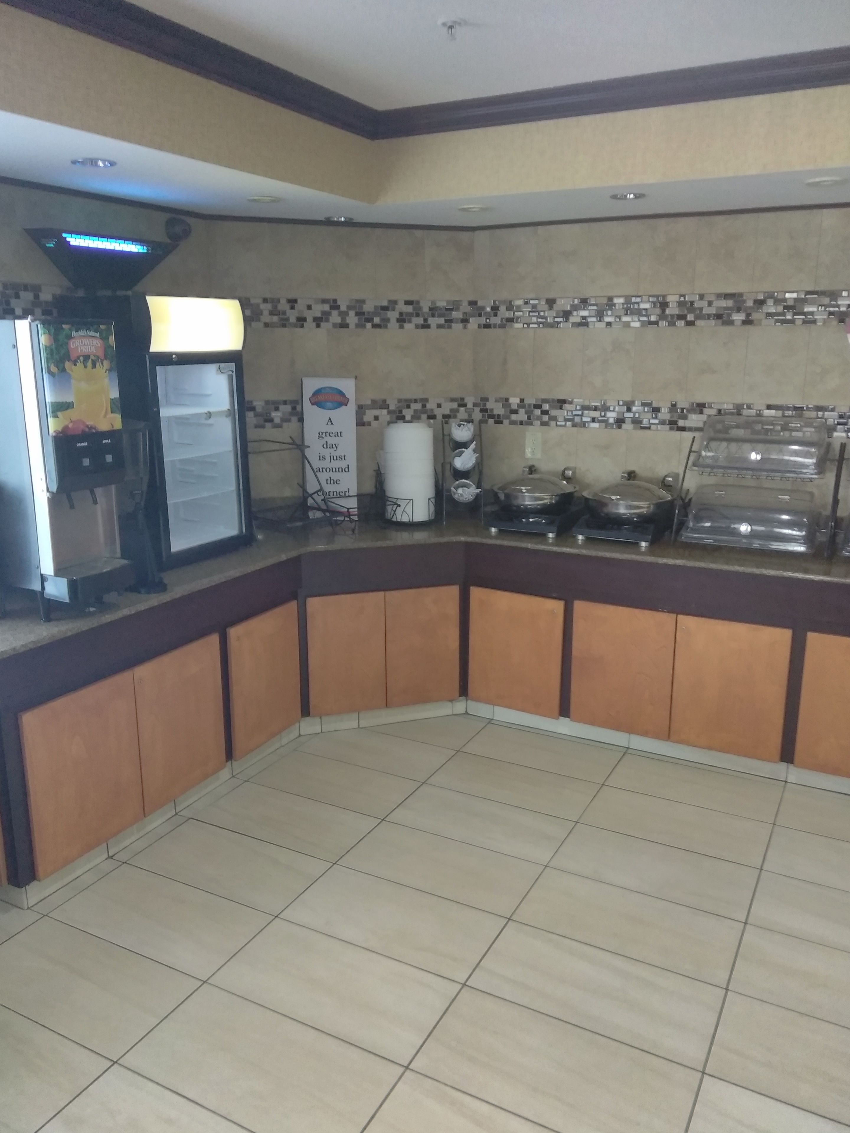 Un coin d’une chambre d’hôtel avec un espace kitchenette comprenant une machine à café, un réfrigérateur et un four à micro-ondes.
