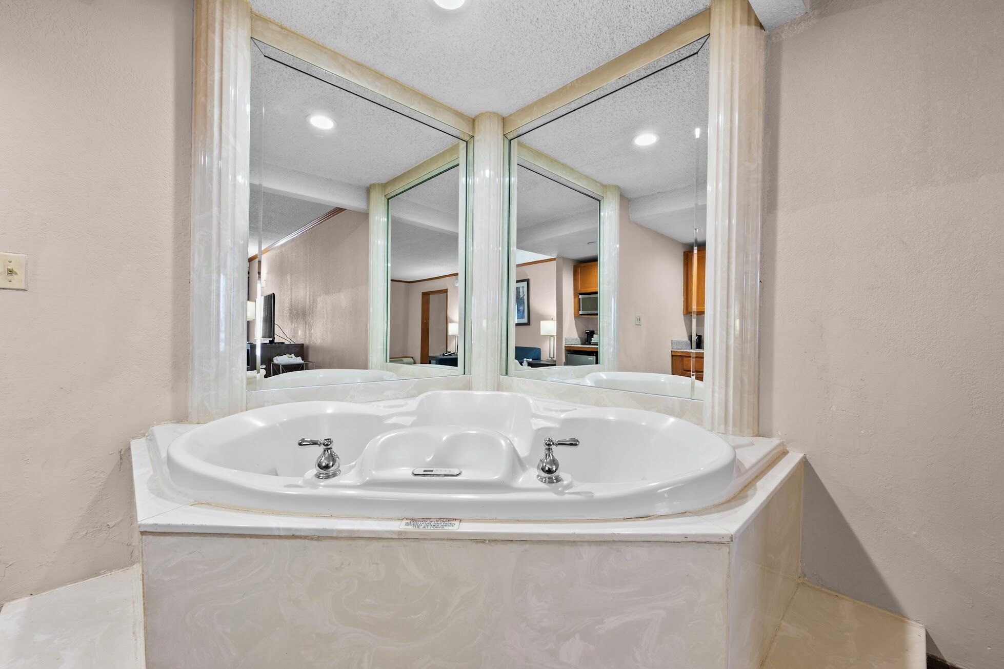 A bathroom with a large freestanding bathtub, a double sink, and a mirror above the tub.