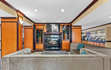 A modern lobby with a fireplace, a seating area, and a breakfast bar.
