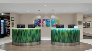 A reception area with two counters, a vending machine, and colorful artwork on the wall.
