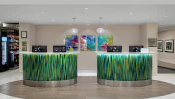 A reception area with two counters, a vending machine, and colorful artwork on the wall.