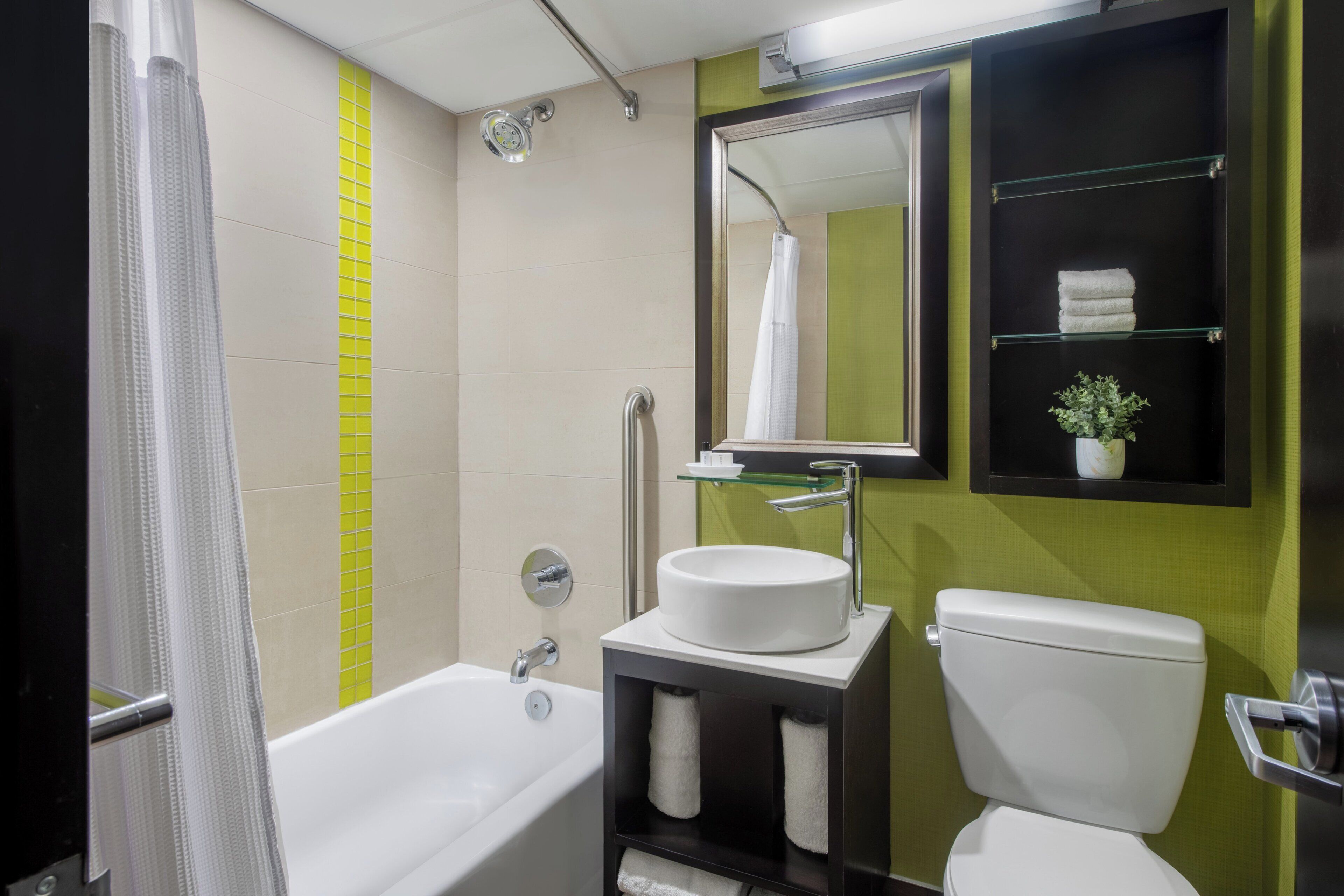 Une salle de bain avec une baignoire, des toilettes et un lavabo avec un miroir au-dessus.