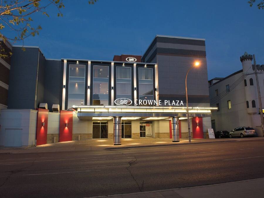A hotel with a modern facade, large windows, and a prominent sign reading 'CROWNE PLAZA'.