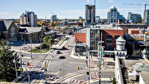 A cityscape with a mix of modern and historic buildings, a prominent tower, and a busy intersection.