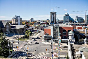 A cityscape with a mix of modern and historic buildings, a prominent tower, and a busy intersection.