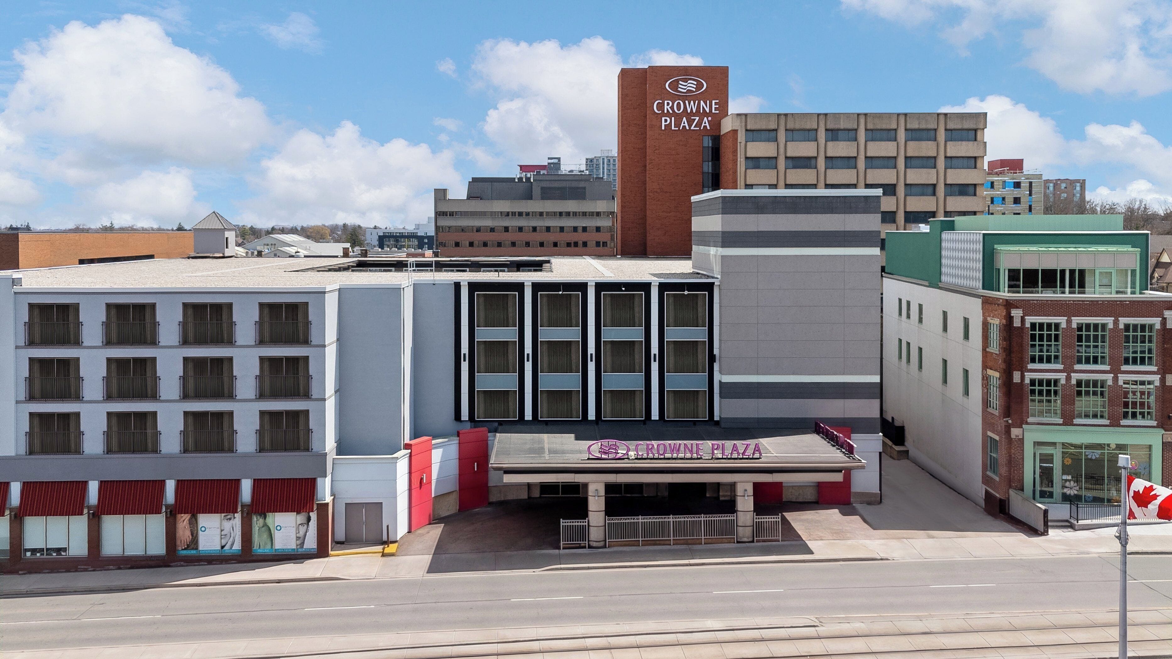 A building with a sign reading 'CROWN PLAZA' and a Canadian flag.