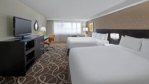 A hotel room with two beds, a TV, a desk, and a chair. - Crowne Plaza Kitchener-Waterloo by IHG (Kitchener)