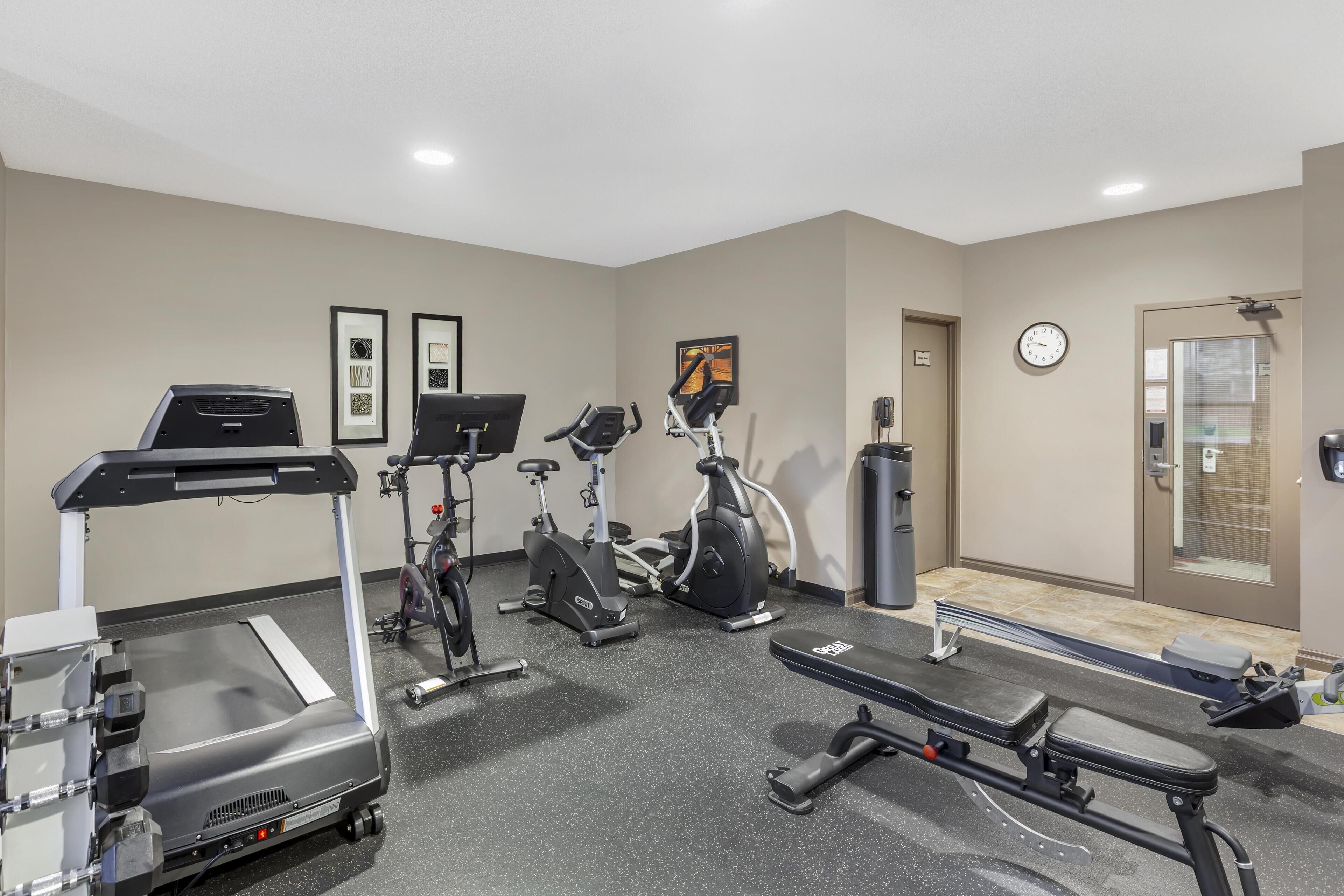 A gym with treadmills, stationary bikes, and a rowing machine.