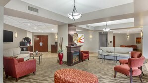 A spacious lobby with a fireplace, sofas, and a patterned carpet. - Best Western Plus Rose City Suites (Welland)