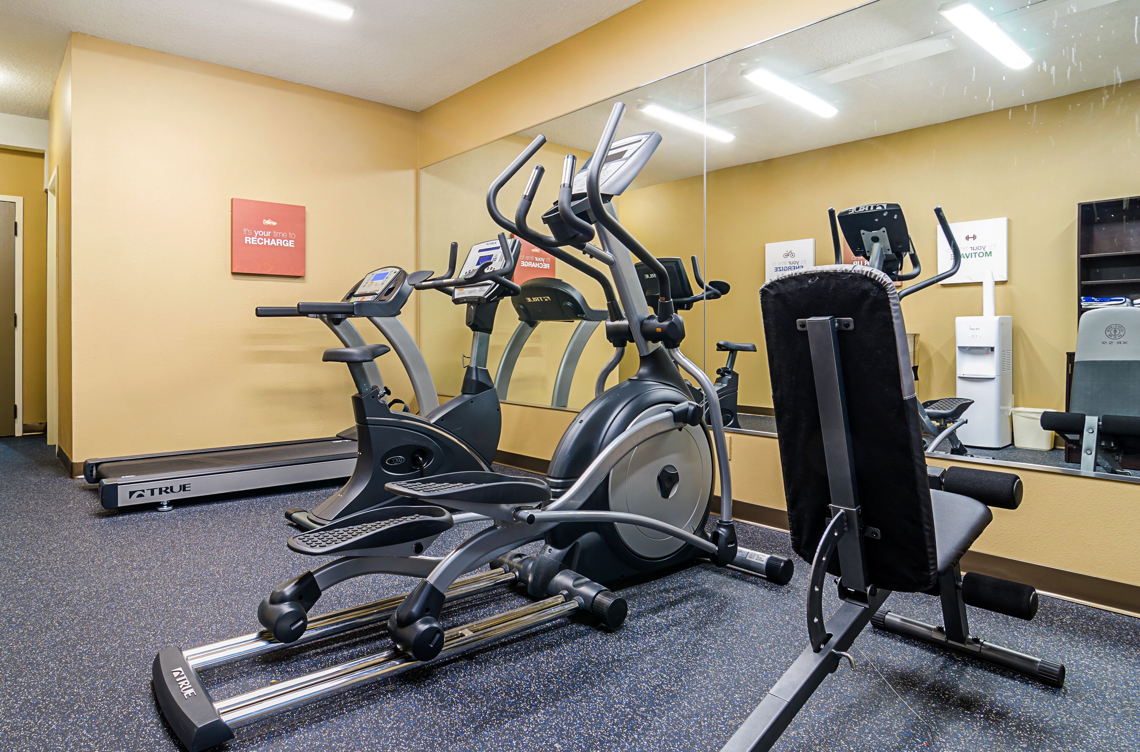 A gym with various exercise equipment, including treadmills and a stationary bike.