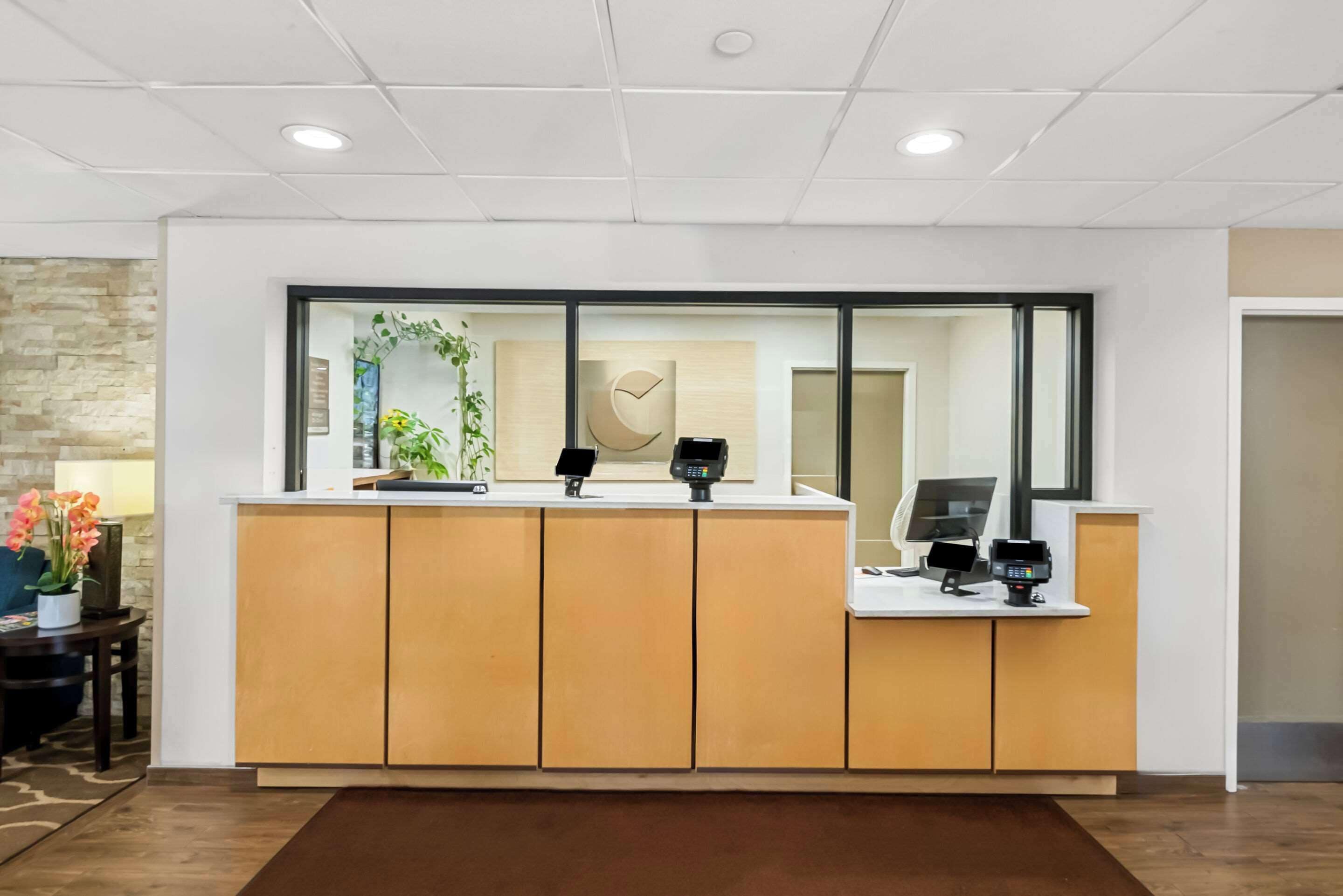 Ein Empfangsschalter mit modernem Design, bestehend aus einer Holztresen und Glaselementen.