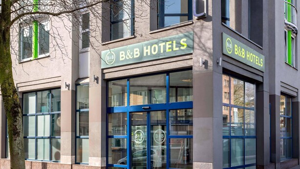Ein Bed & Breakfast Hotel mit moderner Fassade, großen Glasfenstern und einem gut sichtbaren Eingang.