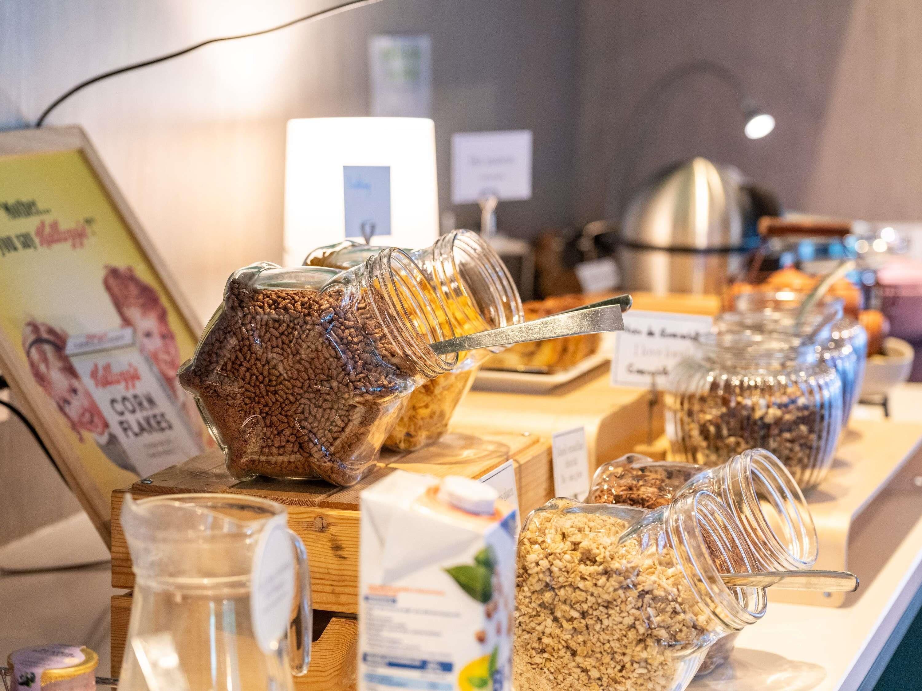 A breakfast buffet with various food items in glass containers.