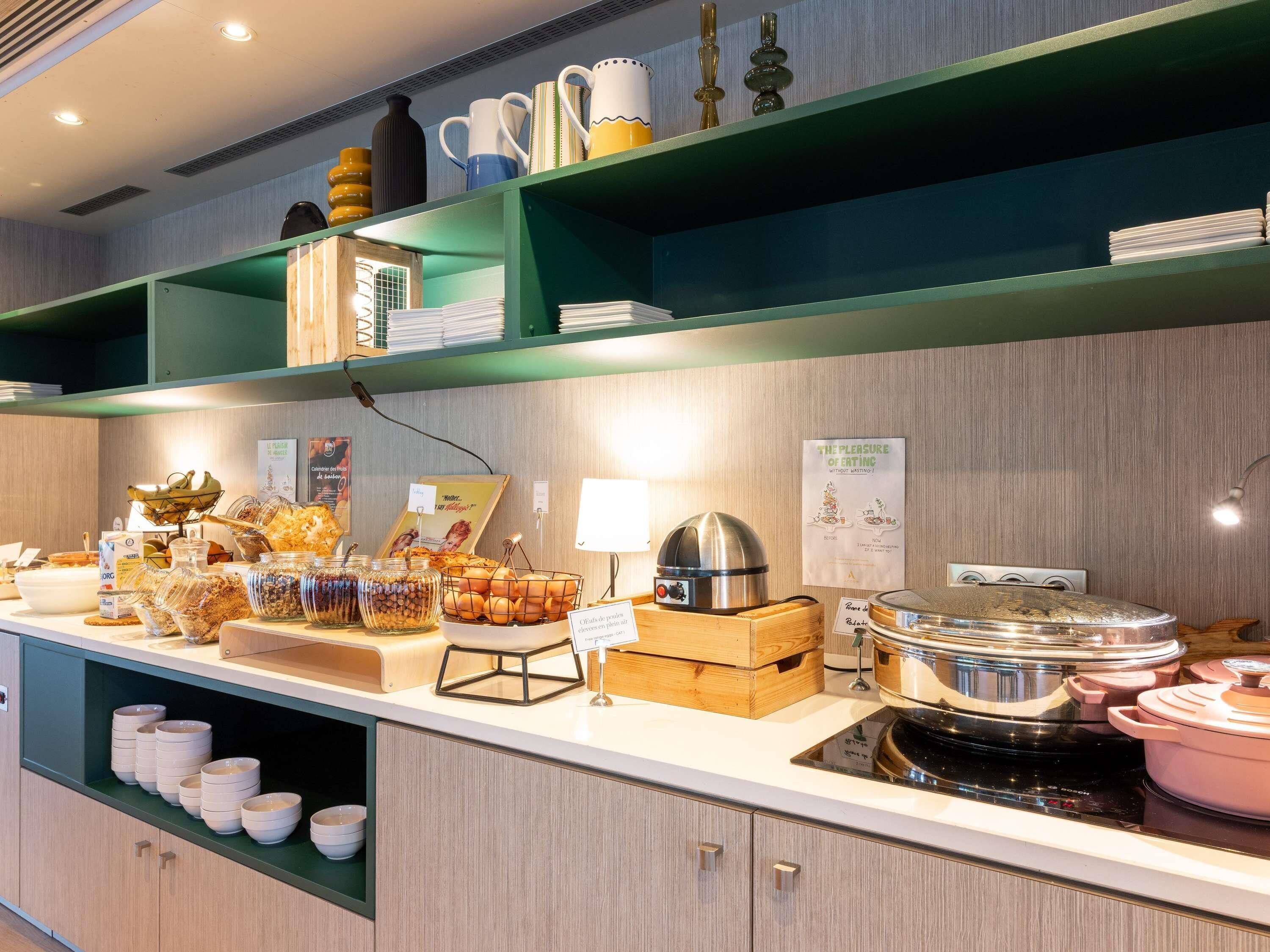 A buffet setup with various food items, a coffee station, and a stove for cooking.