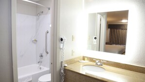 A bathroom with a bathtub, toilet, sink, and a mirror. - Days Inn by Wyndham Monroe LA (Monroe)