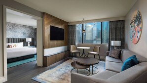 Una camera d'albergo moderna con un letto, un divano, un tavolino e una televisione.