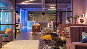 A modern living room with patterned sofas, a coffee table, and a dining area with a bar.