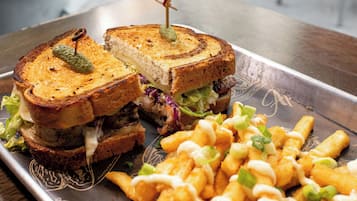 A sandwich with a toothpick, lettuce, and a side of fries.