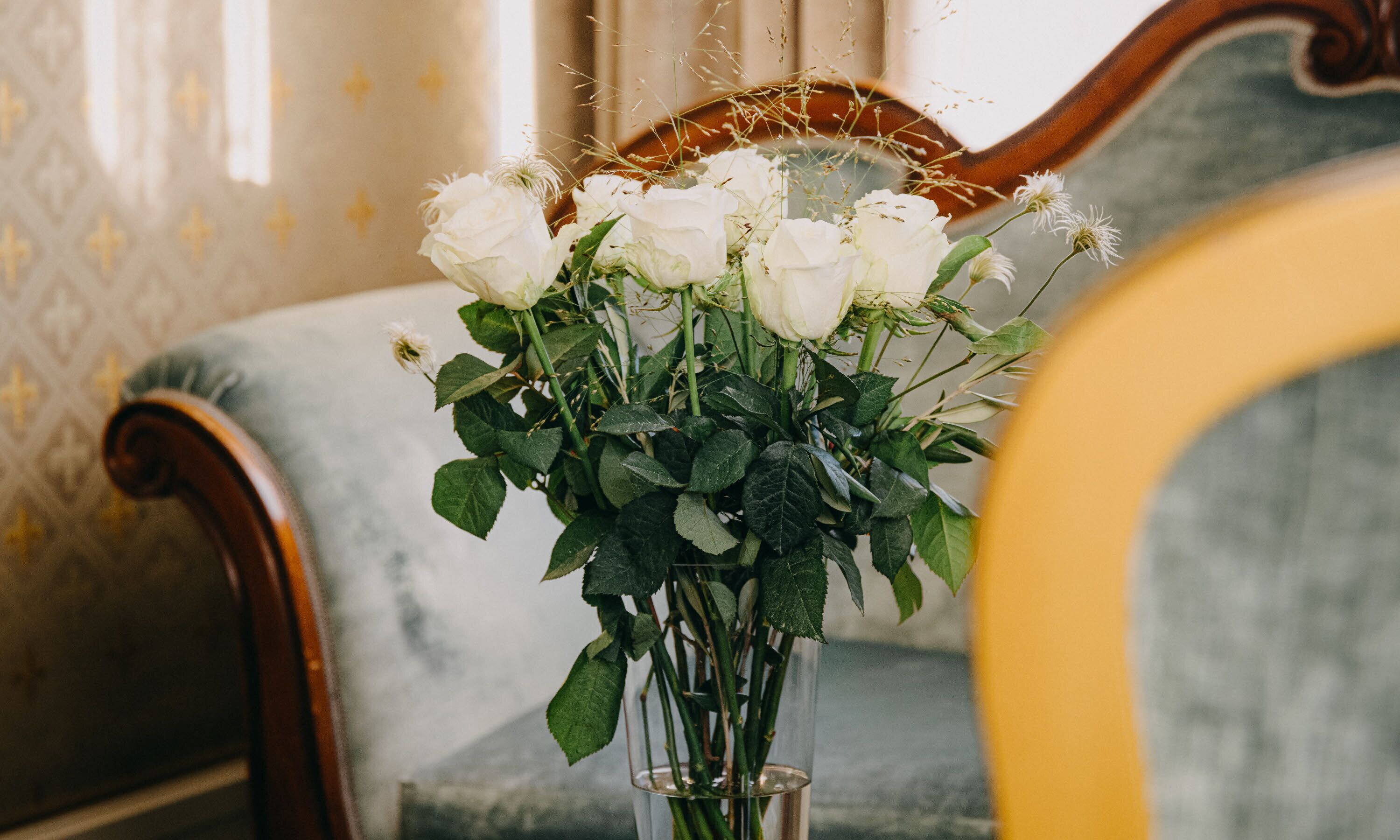 A bouquet of white roses in a clear vase on a table.