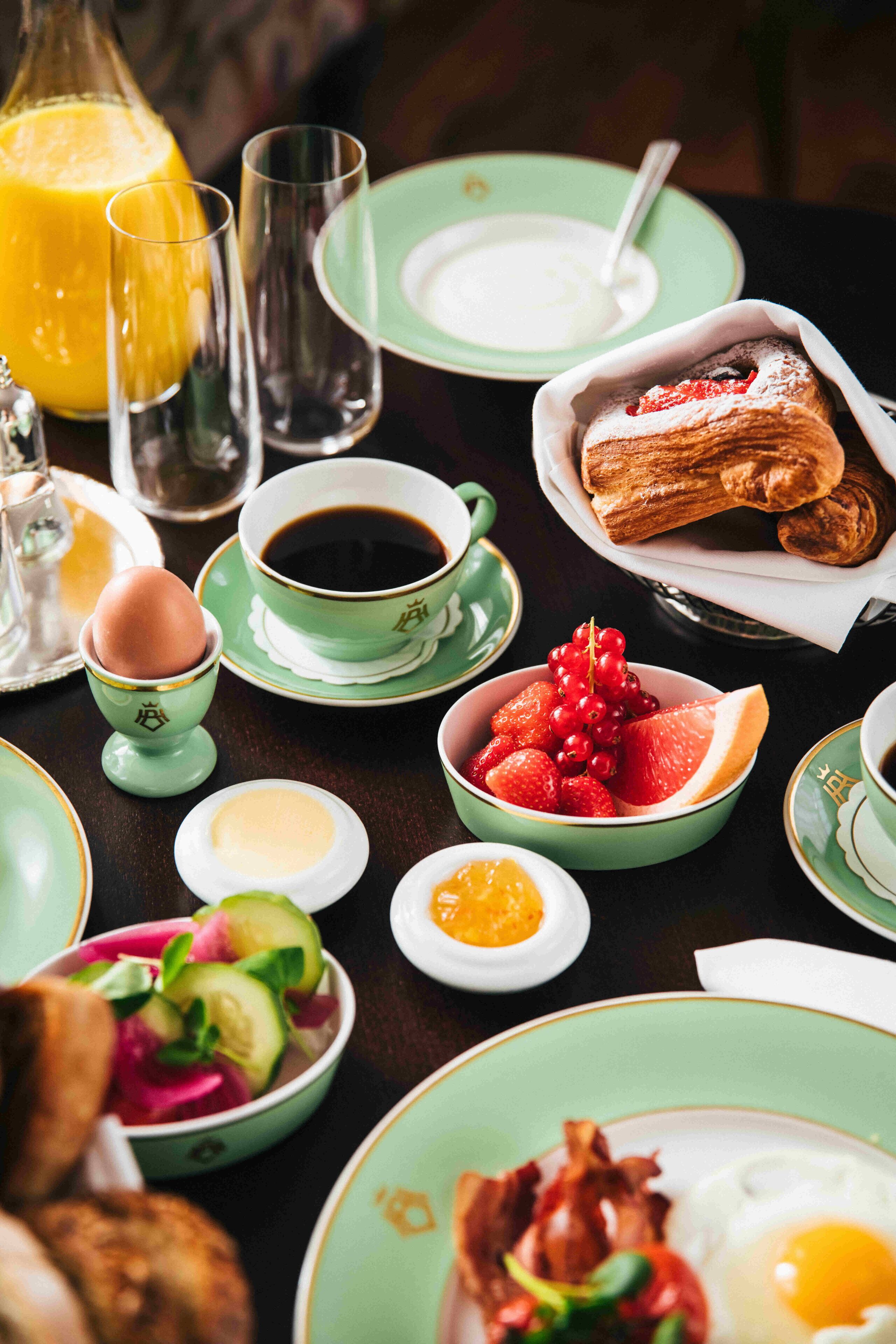 A breakfast table with various dishes including eggs, toast, and fruit.