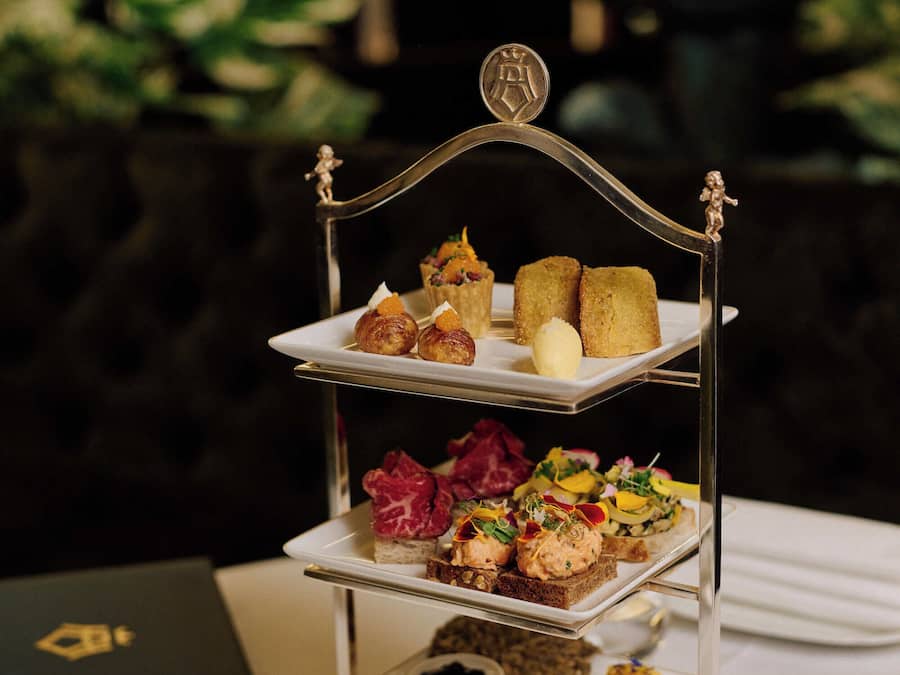A three-tiered dessert stand with various pastries and desserts.