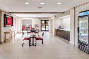 Un comedor moderno con televisor de pantalla plana, refrigerador y cafetera.