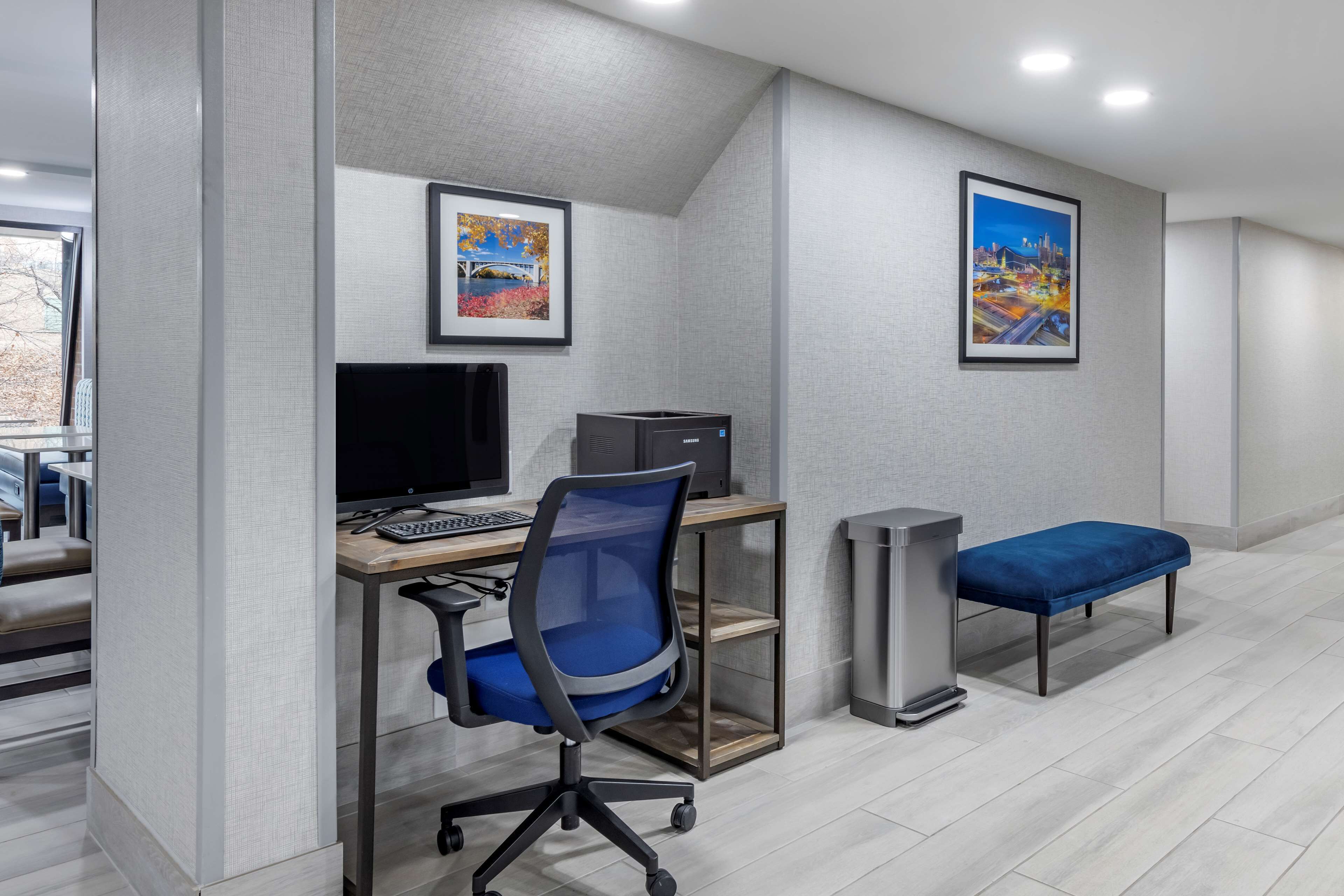 Un espacio de oficina moderno con un escritorio, computadora, silla y un banco.