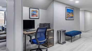 Un espacio de oficina moderno con un escritorio, computadora, silla y un banco.