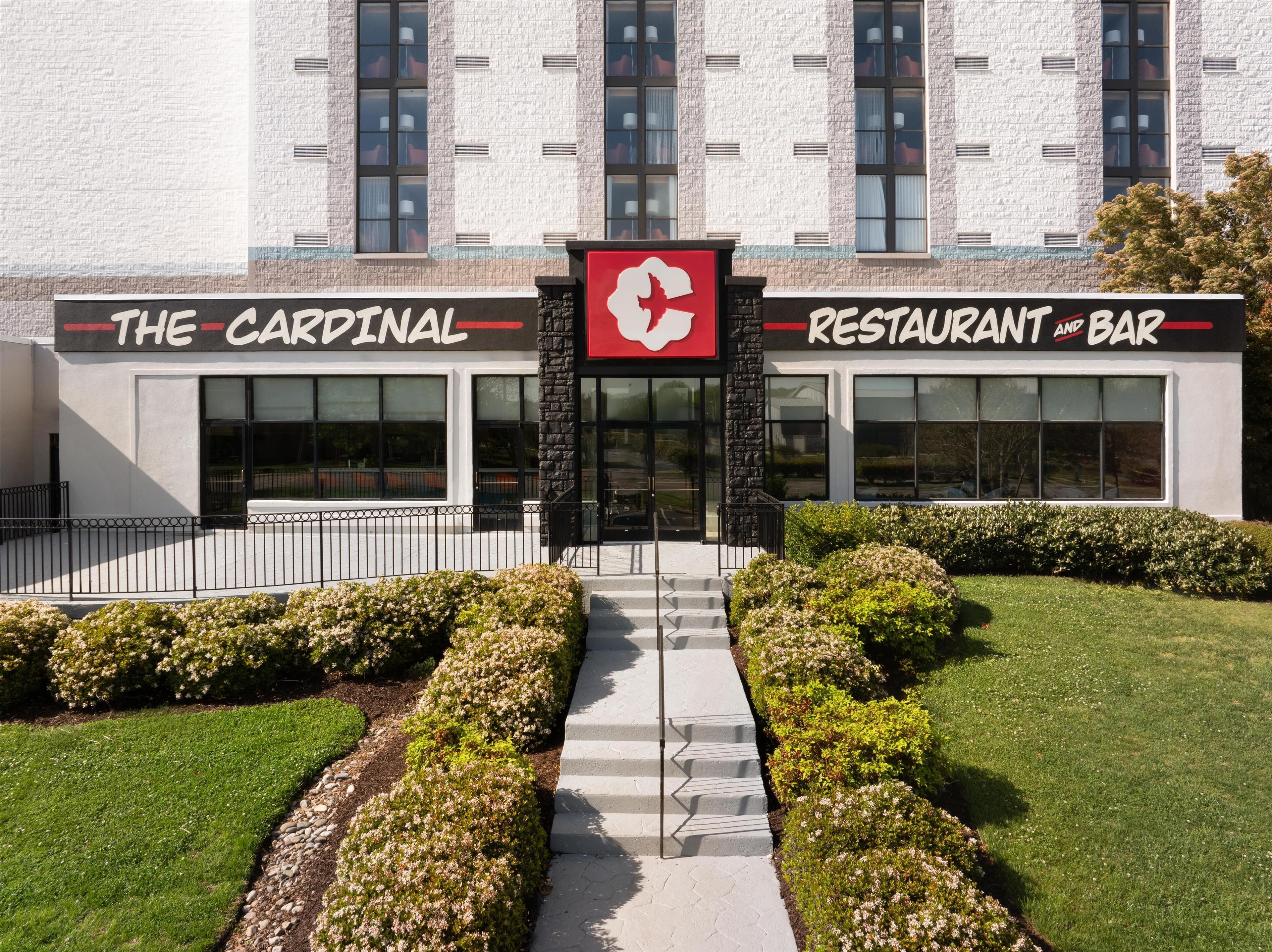 A building with a sign reading "The Cardinal Restaurant and Bar" and a logo above the entrance.
