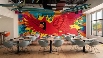 A modern dining area with colorful murals, contemporary furniture, and large windows.