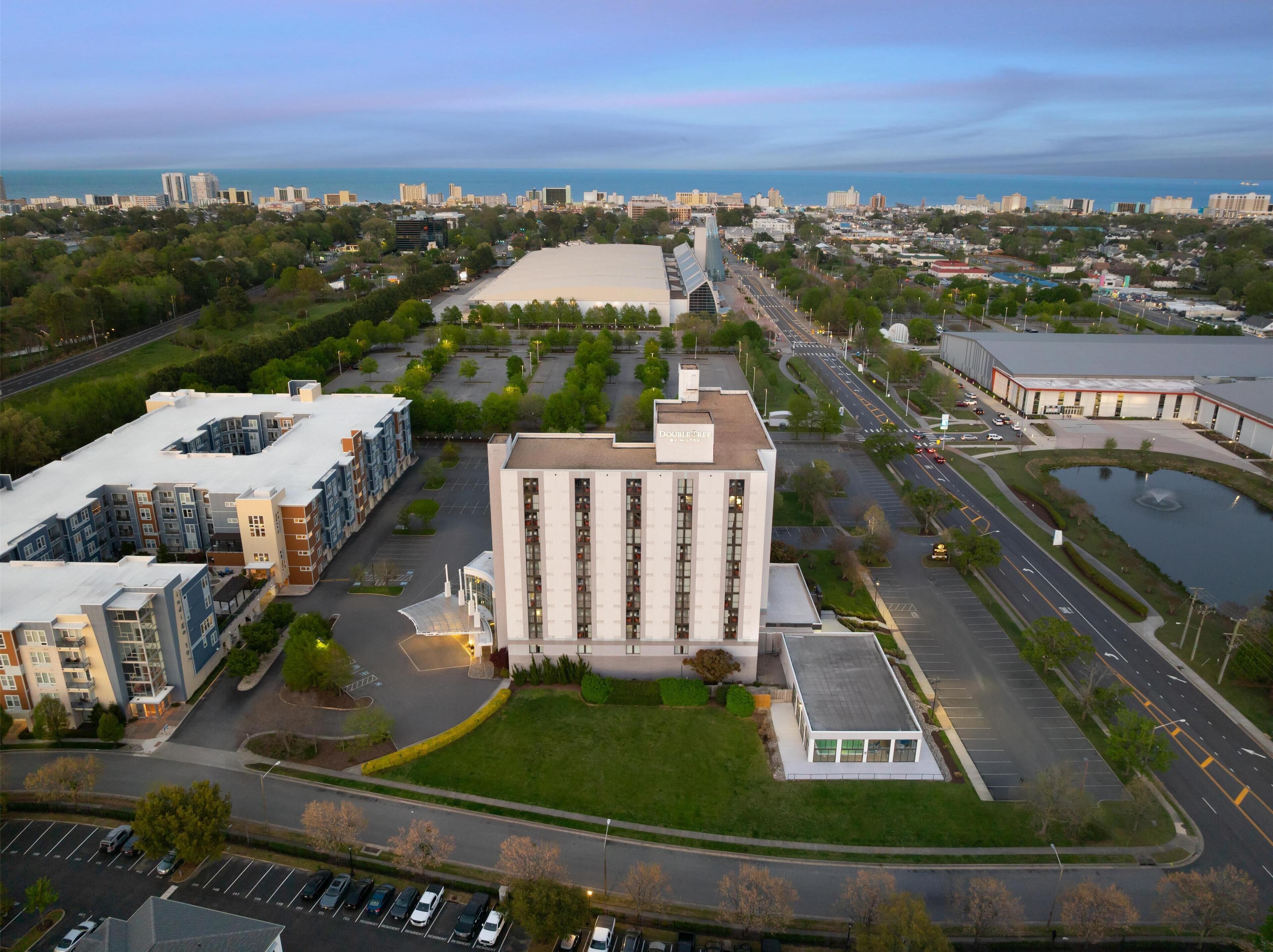 Un grand hôtel doté d’une cour intérieure, entouré de places de stationnement et de routes.