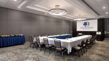 A conference room with a long table, chairs, and a podium.