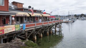 A pier extending over calm water with boats docked nearby. - The Monterey Hotel (Monterey)