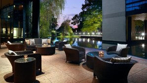 An outdoor seating area with wicker furniture and a pool.