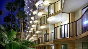 Un hôtel au design moderne, doté de balcons aux lignes courbes et d’une série de fenêtres.