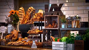 Une vitrine de boulangerie présentant diverses pâtisseries, une enseigne indiquant « ÉPICES » et une autre indiquant « MARCHÉ DES PRODUCTEURS ».