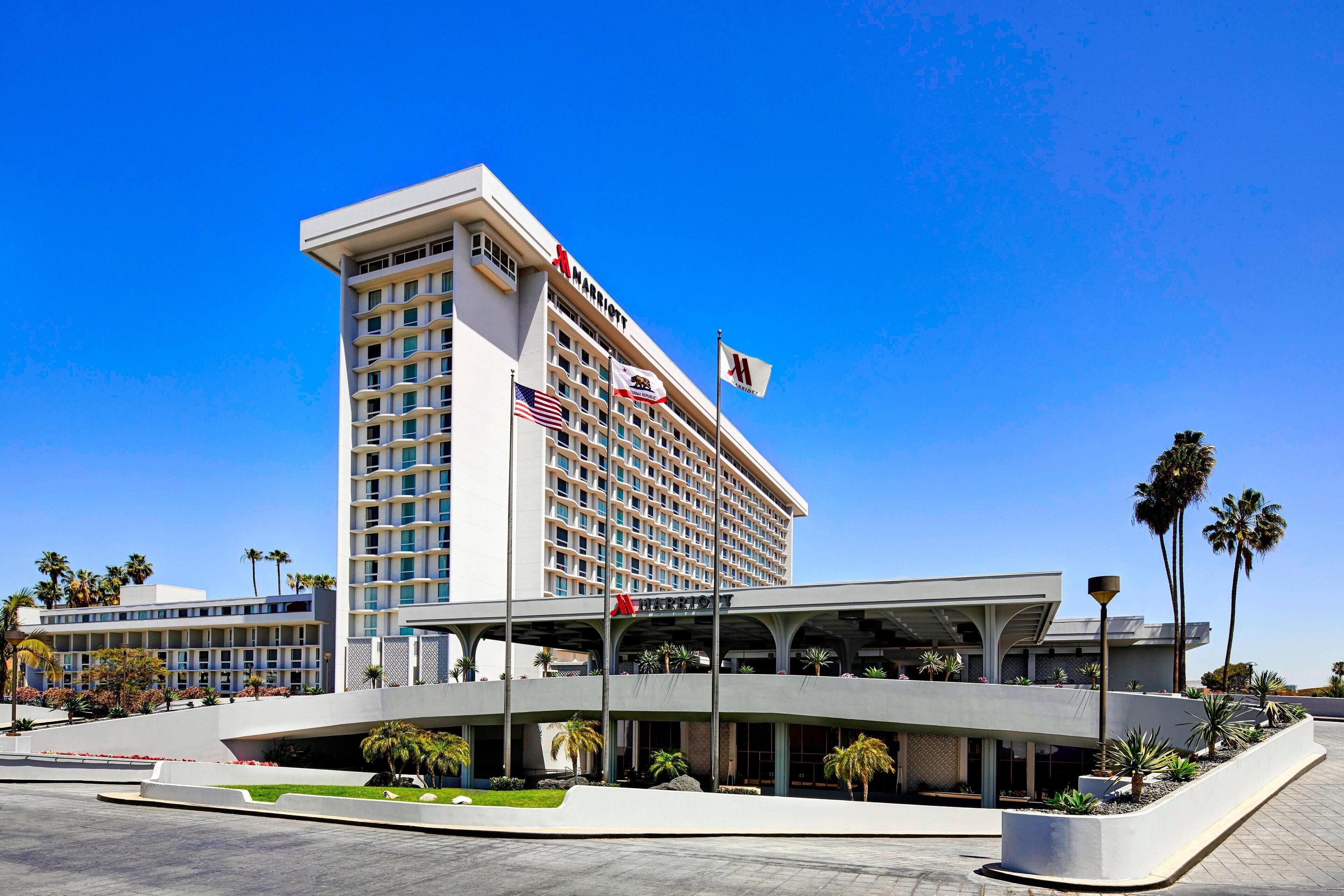 A multi-story hotel with a modern design, featuring a prominent American flag and a Marriott logo.