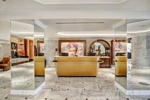 A luxurious lobby with a marble floor, a reception desk, and a large mirror reflecting the space. - Hotel Paso Del Norte, Autograph Collection (El Paso)