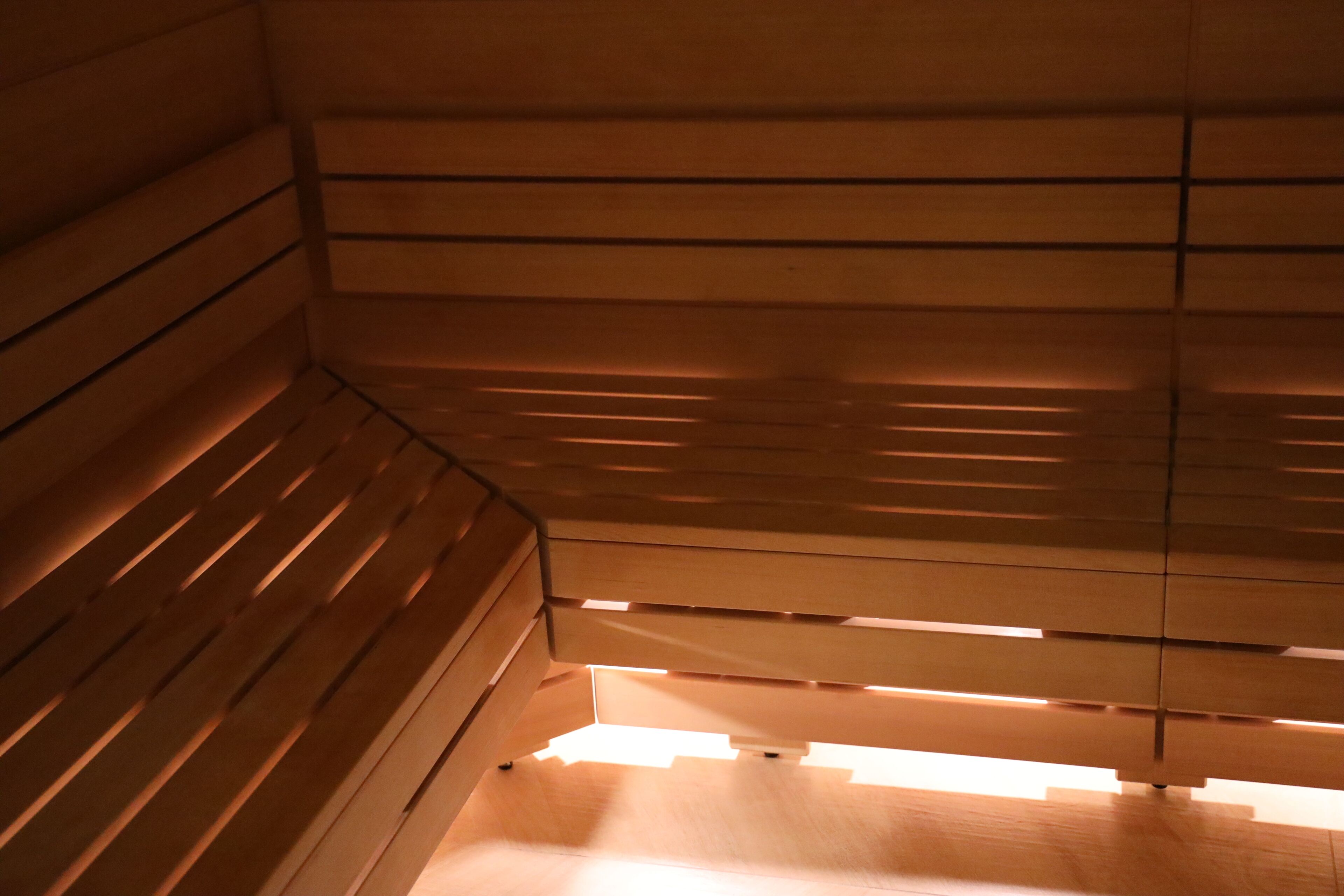 A wooden interior with slatted walls and a bench.