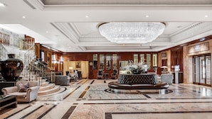 A spacious lobby with a grand chandelier, marble flooring, and a leather sofa. - Radisson Blu Hotel, London Heathrow (Hayes)