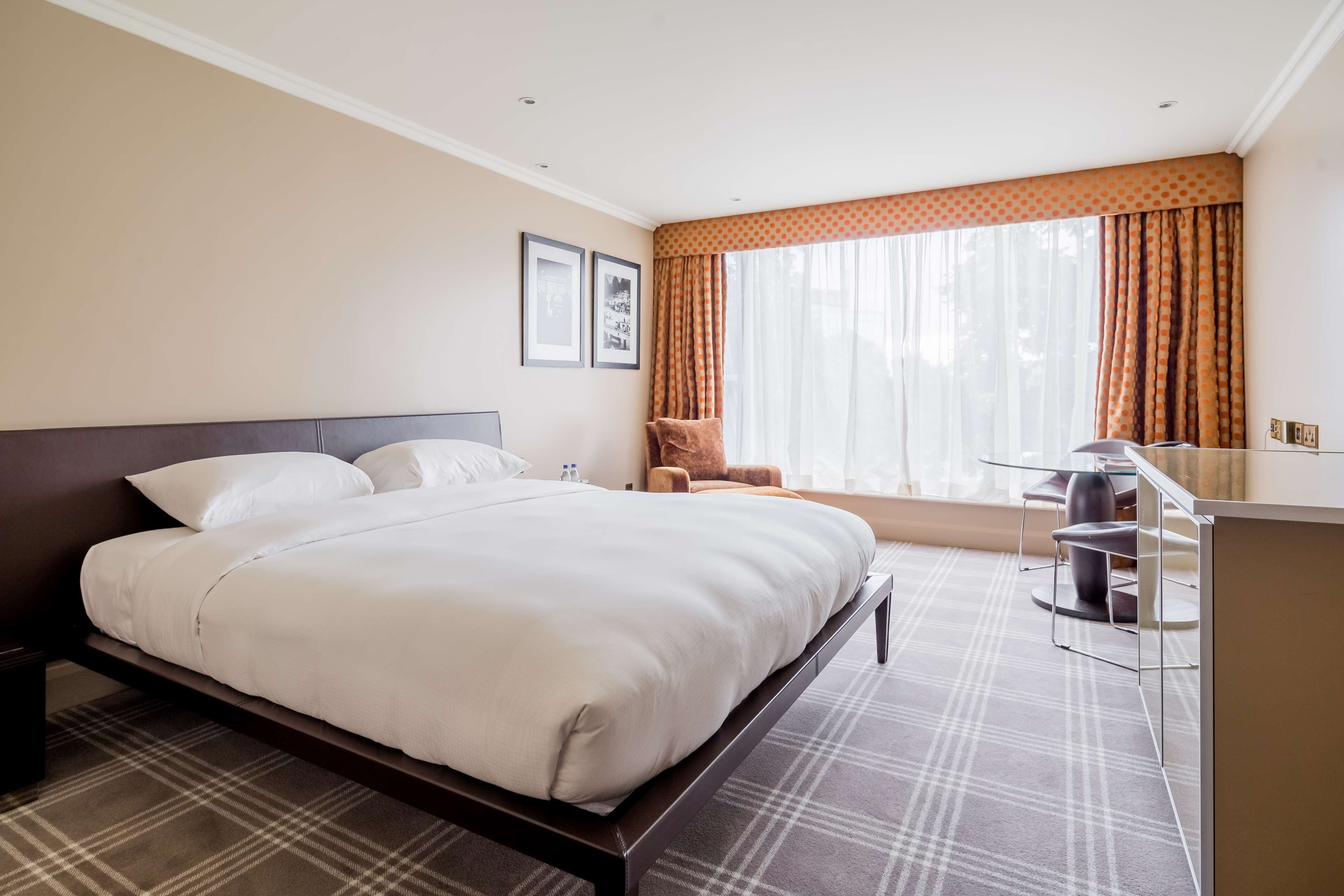 Una habitación de hotel con una cama grande, un escritorio y una silla.