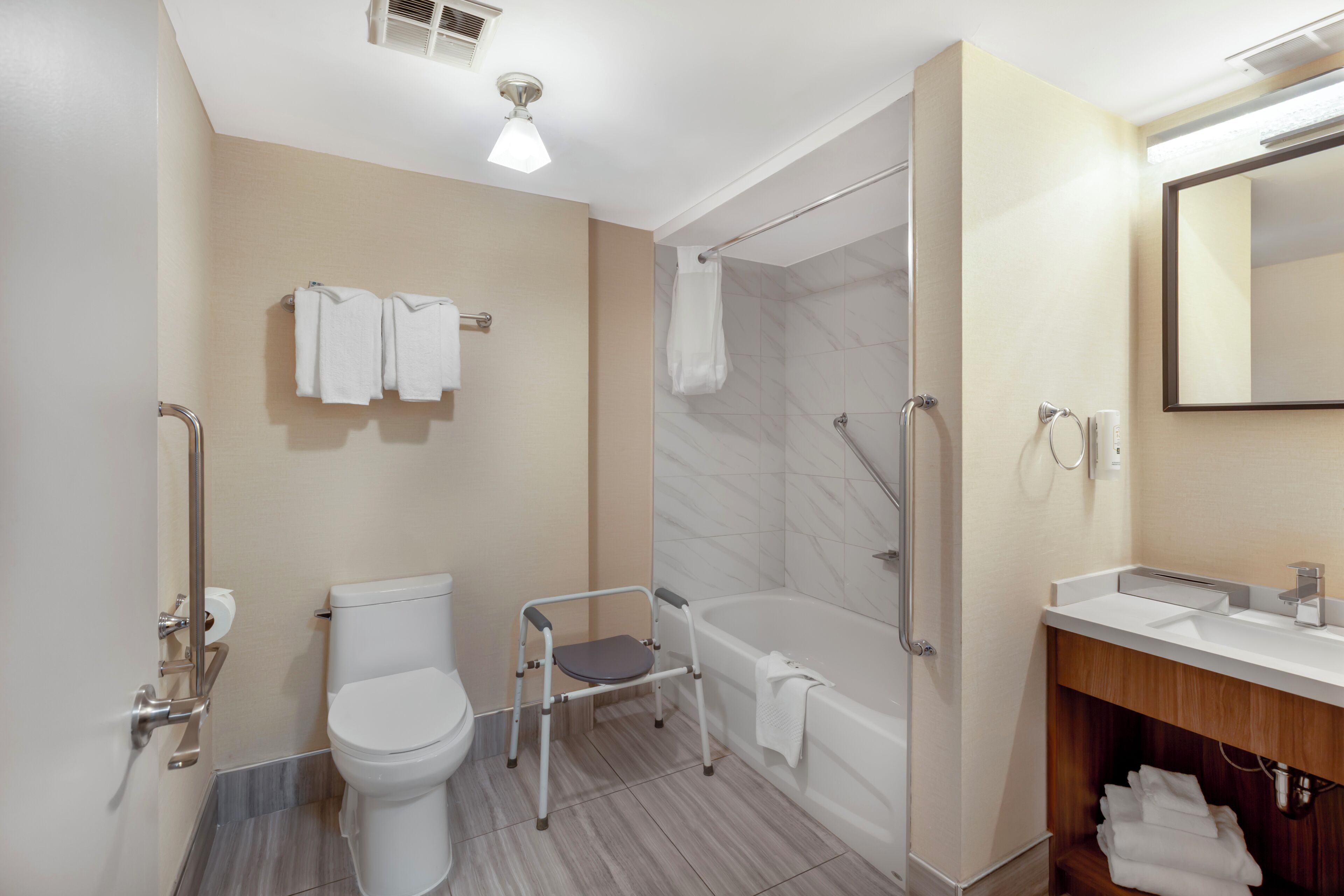 A modern bathroom with a toilet, shower, and sink.